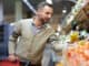 Portrait of smiling handsome man grocery shopping in supermarket