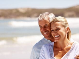 Happy mature couple embracing on a sunny day at the beach