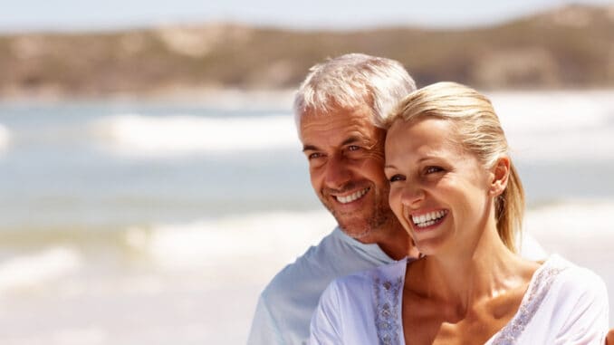 Happy mature couple embracing on a sunny day at the beach