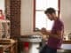 Young man using tablet computer in kitchen, waist up