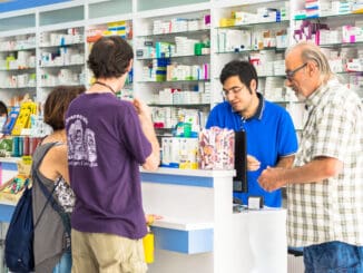 young pharmacist helping customers at the counter