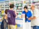 young pharmacist helping customers at the counter